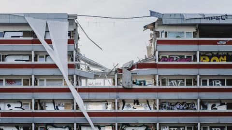Baukräne reißen in Berlin eine Gebäude ein.