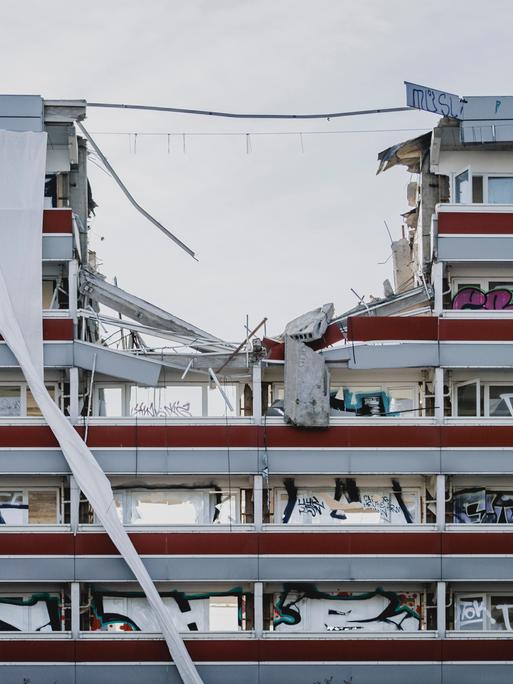 Baukräne reißen in Berlin eine Gebäude ein.