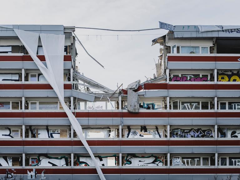 Baukräne reißen in Berlin eine Gebäude ein.