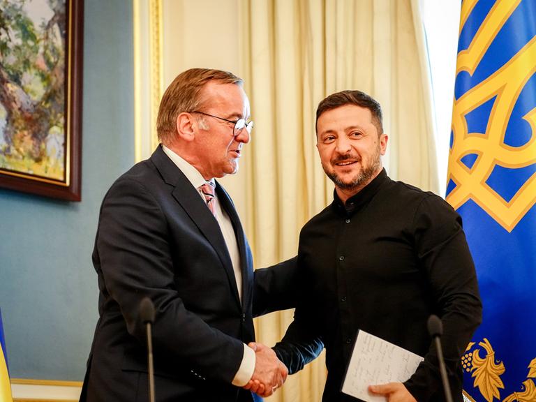 Boris Pistorius (l, SPD), Bundesminister der Verteidigung, und Wolodymyr Selenskyj, Präsident der Ukraine, stehen nebeneinander und geben eine Pressekonferenz