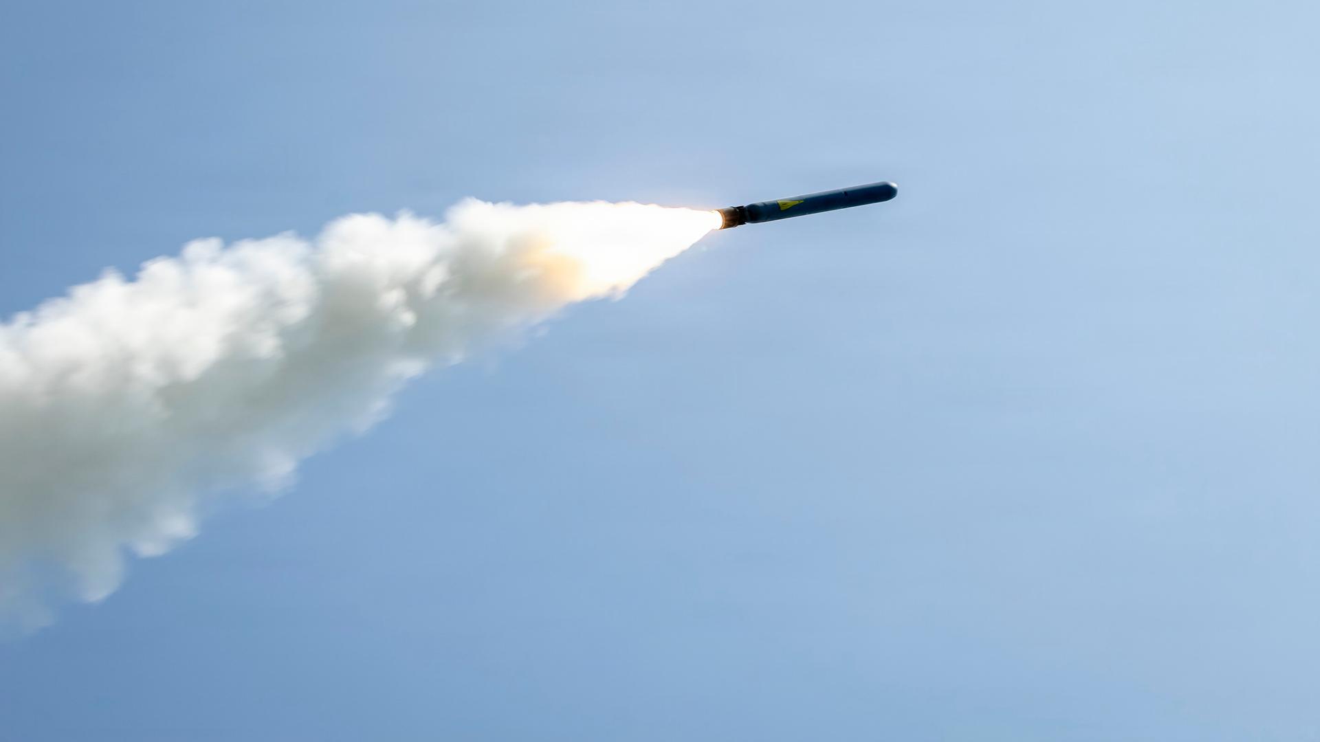 Ein abgefeuertes Raketengeschoss fliegt am Himmel und zieht eine Rauchwolke hinter sich her.