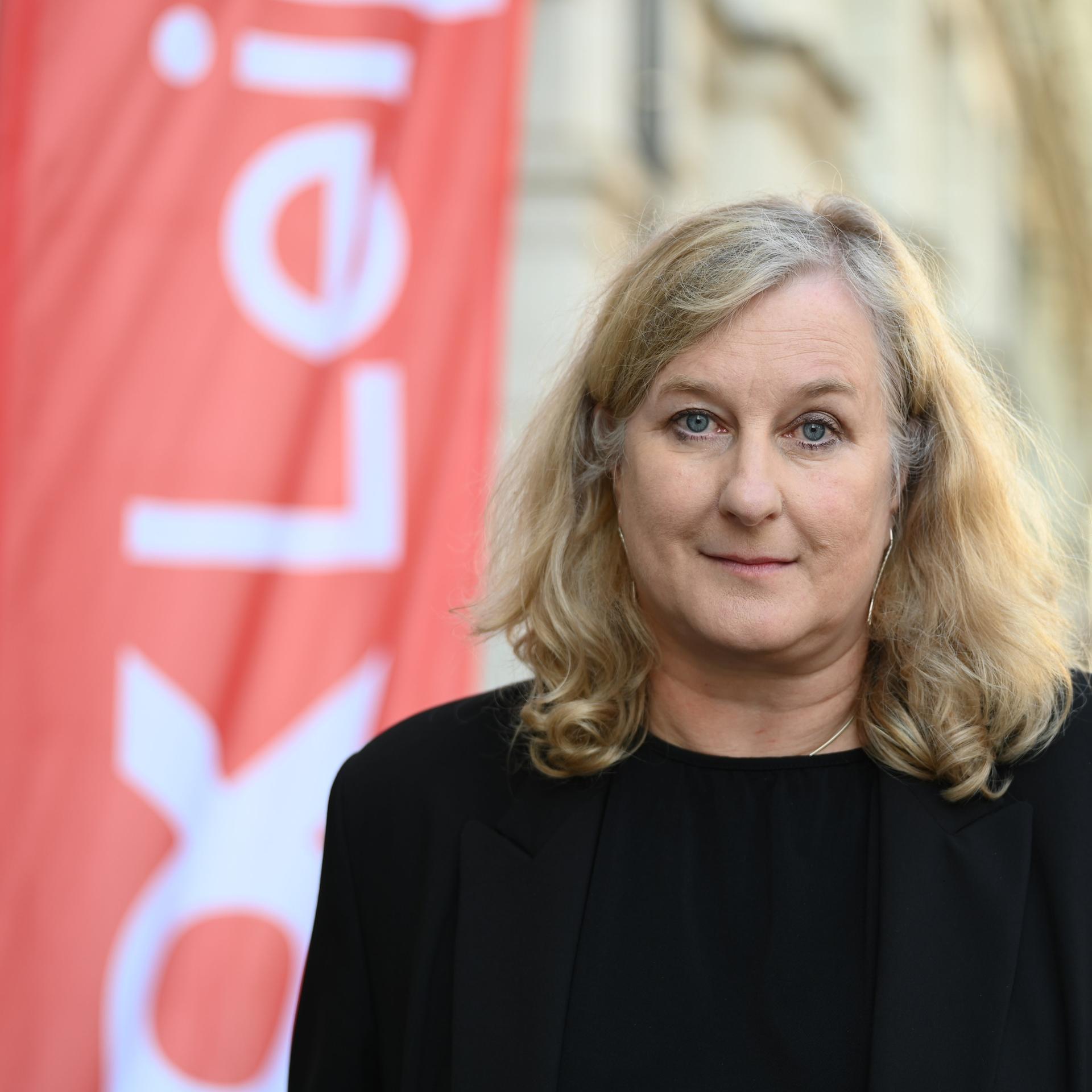 Ola Staszel, die neue Leiterin des Dokumentarfilm-Festivals DOK Leipzig, steht vor einem Gebäude.