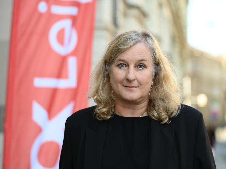 Ola Staszel, die neue Leiterin des Dokumentarfilm-Festivals DOK Leipzig, steht vor einem Gebäude.