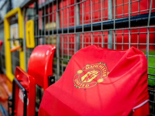 Ein rotes Trikot mit der Aufschrift Manchester United hängt über einem Klappstuhl im Stadion 