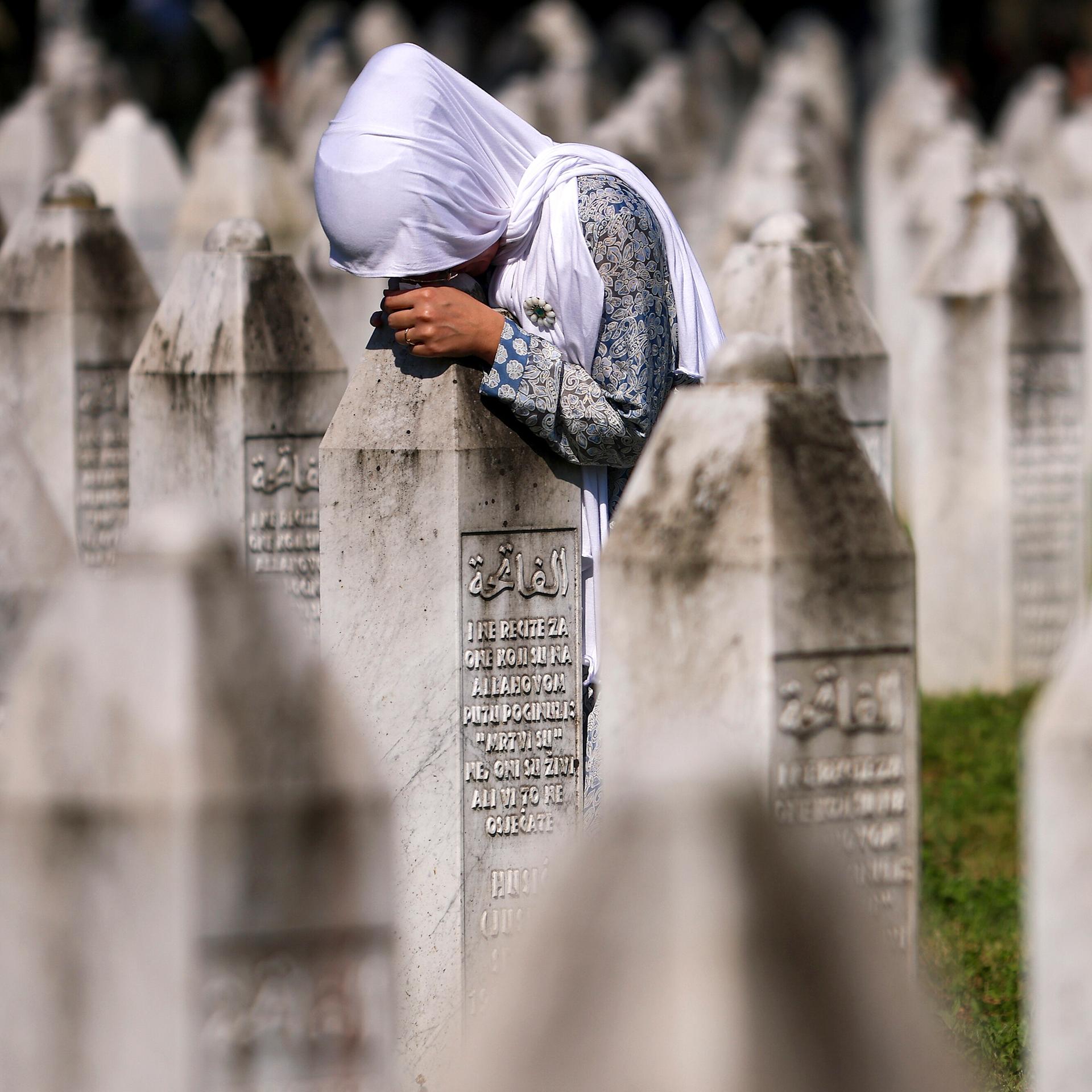Eine muslimische Frau trauert am Grab ihres Verwandten in der Srebrenica-Gedenkstätte in Potocari, Bosnien. Eine muslimische Frau trauert am Grab ihres Verwandten in der Srebrenica-Gedenkstätte in Potocari, Bosnien.