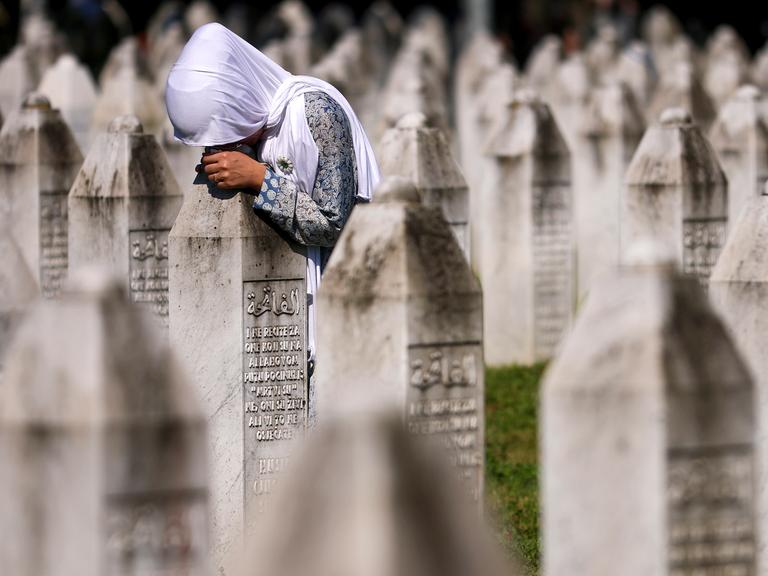 Eine muslimische Frau trauert am Grab ihres Verwandten in der Srebrenica-Gedenkstätte in Potocari, Bosnien.