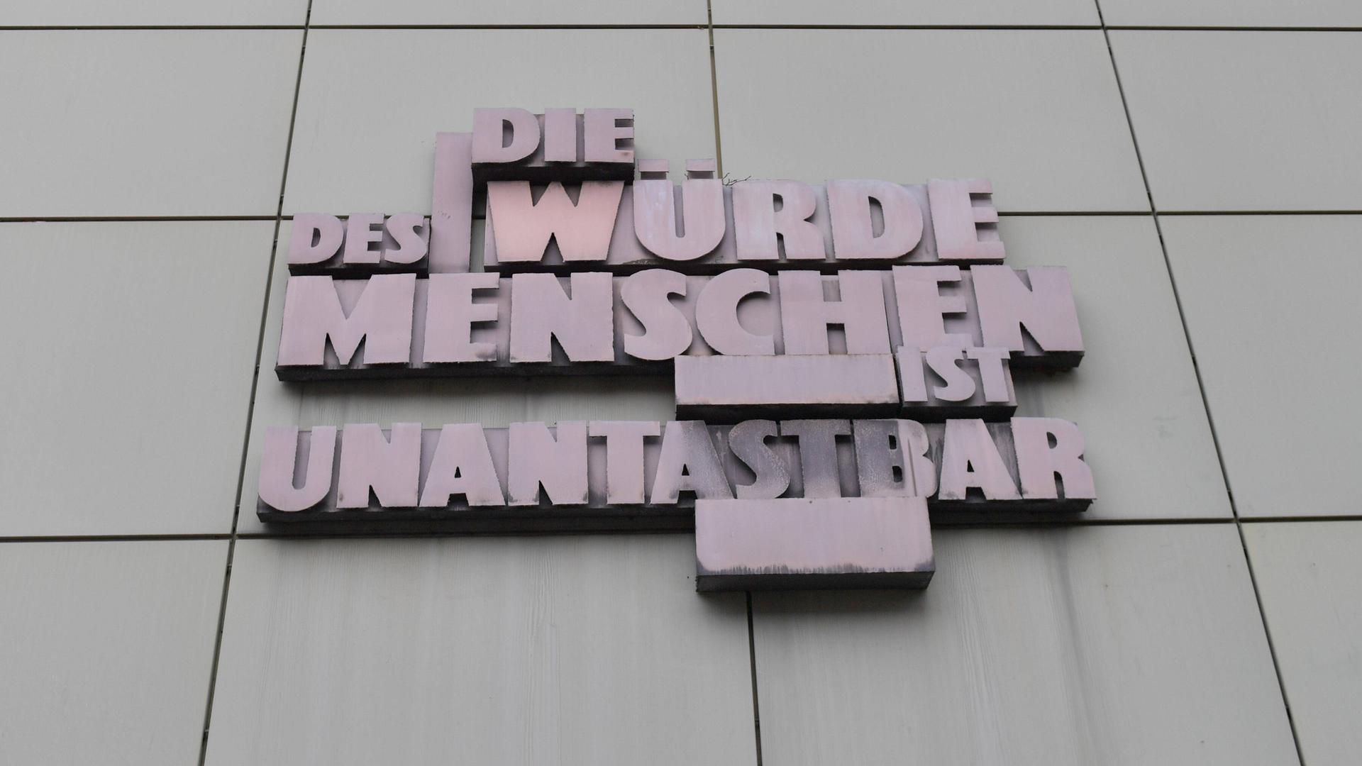 Der Schriftzug "Die Würde des Menschen ist unantastbar" steht in Großbuchstaben aus Metall an einem Gerichtsgebäude in Frankfurt am Main. Der Schriftzug "Die Würde des Menschen ist unantastbar" steht in Großbuchstaben aus Metall an einem Gerichtsgebäude in Frankfurt am Main.