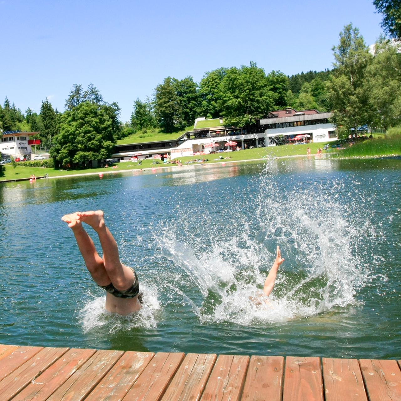 Kinder springen in das Wasser während der Hitzewelle im Strandbad Kirchbichl.