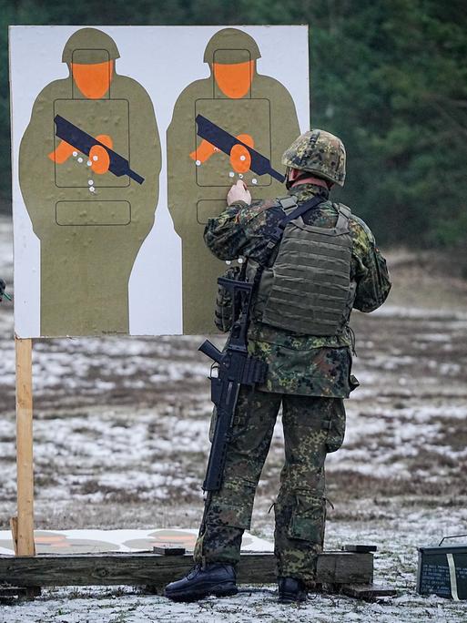 Zwei Bundeswehrsoldaten trainieren mit dem G36-Gewehr auf einem Truppenübungsplatz mit Pappsoldaten als Zielscheibe. 