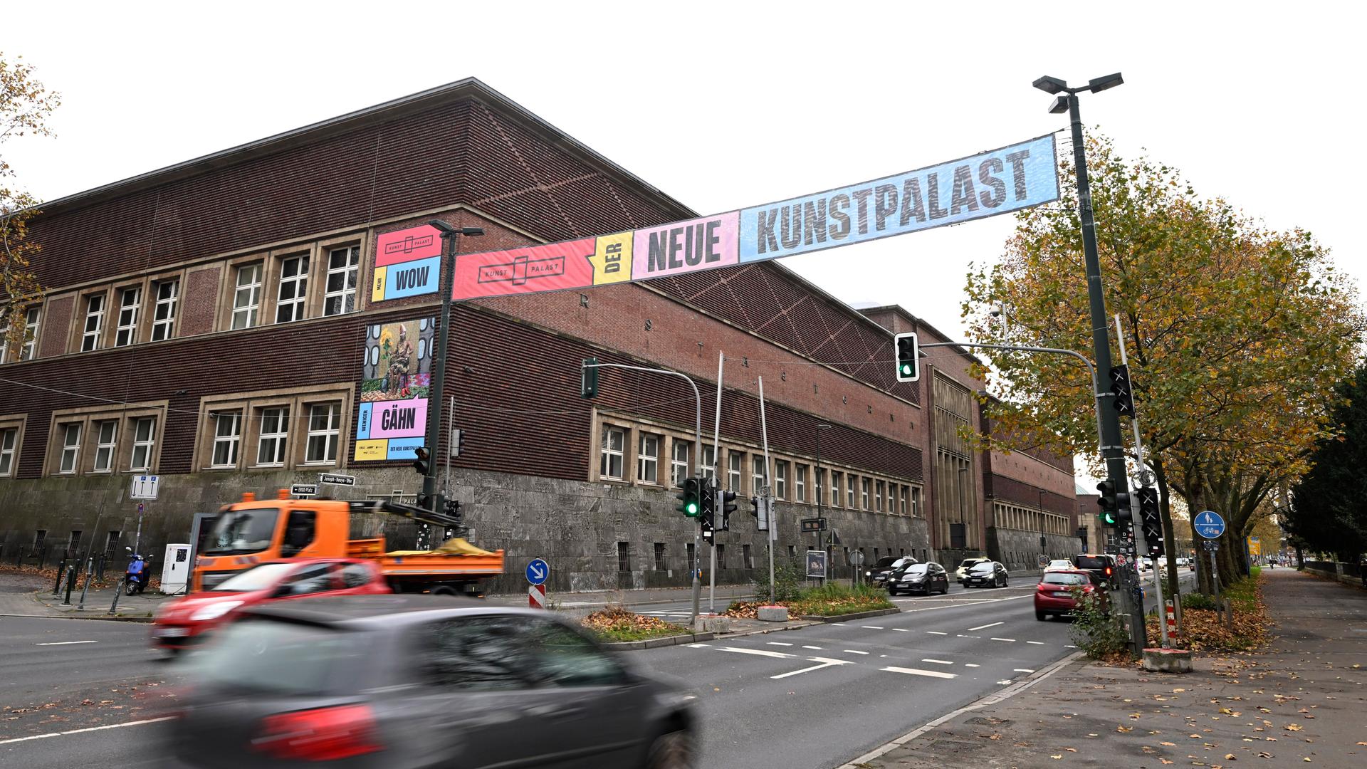 Quer über die Straße gespannte Banner weisen die Passanten auf die Wiedereröffnung des Kunstpalastes hin. Am Straßenrand sieht man das Gebäude des Kunstpalastes. Quelle: dpa