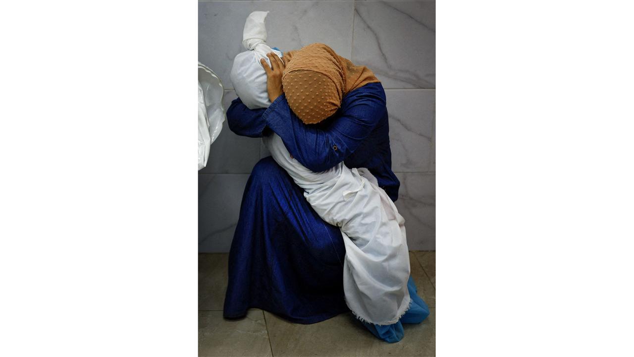 Das "World Press Photo" des Jahres: Das Foto zeigt Ina Abu Maamar, die ein blaues Kleid und ein ockerfarbenes Kopftuch trägt. Sie beugt sich über den in ein weißes Laken gehüllten Leichnam ihrer fünf Jahre alten Nichte Saly
