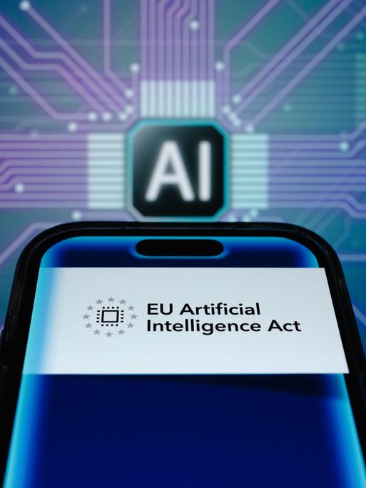 Symbolbild zum EU IA Act: ein Smartphone mit der Aufschrift "EU Artificial Intelligence Act" vor einer Platine mit der Aufschrift "AI". Symbolbild zum EU IA Act: ein Smartphone mit der Aufschrift "EU Artificial Intelligence Act" vor einer Platine mit der Aufschrift "AI".