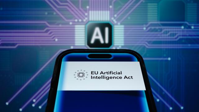 Symbolbild zum EU IA Act: ein Smartphone mit der Aufschrift "EU Artificial Intelligence Act" vor einer Platine mit der Aufschrift "AI".