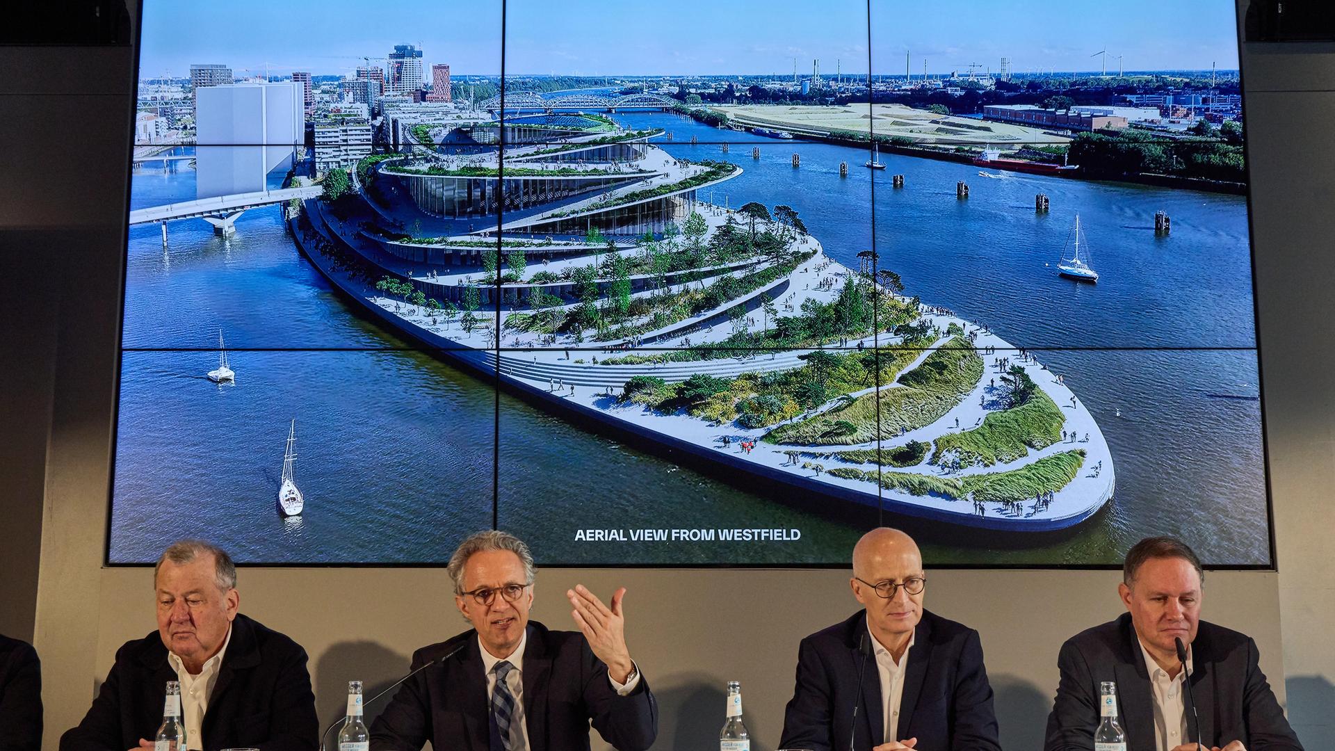 Stefan Behnisch (l-r), Architekt, Jörg Dräger, Geschäftsführender Stiftungsrat der Kühne-Stiftung, Peter Tschentscher, Erster Bürgermeister, und Carsten Brosda, Senator für Kultur und Medien (beide SPD) vor dem Siegerentwurf der Bjarke Ingels Group. Stefan Behnisch (l-r), Architekt, Jörg Dräger, Geschäftsführender Stiftungsrat der Kühne-Stiftung, Peter Tschentscher, Erster Bürgermeister, und Carsten Brosda, Senator für Kultur und Medien (beide SPD) vor dem Siegerentwurf der Bjarke Ingels Group.