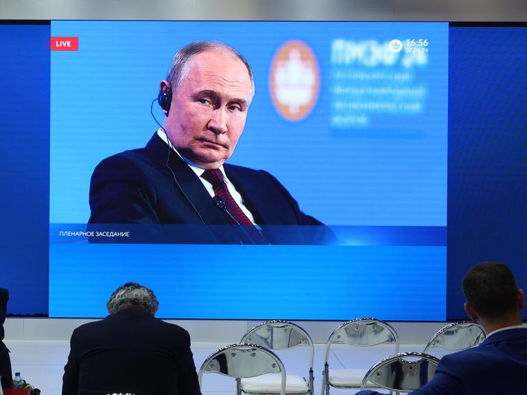 Russlands Präsident Putin ist während einer Videoschalte auf einem Bildschirm zu sehen. 