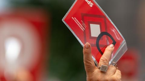 Die Hand einer Frau hält während des Brandenburger SPD-Landesparteitages eine rote Stimmkarte hoch. 