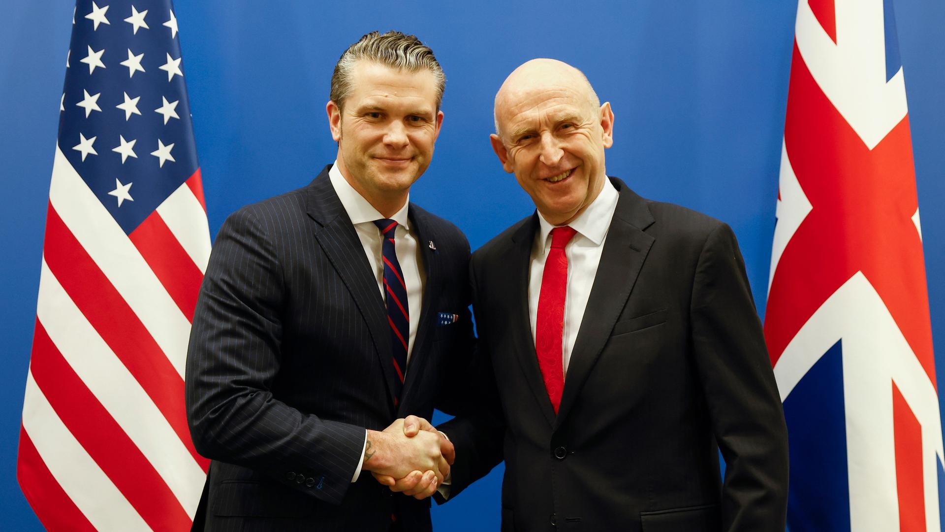 US-Verteidigungsminister Pete Hegseth (l) schüttelt dem britischen Verteidigungsminister John Healey vor einem bilateralen Treffen am Rande eines Treffens der NATO-Verteidigungsminister im NATO-Hauptquartier in Brüssel die Hand. 