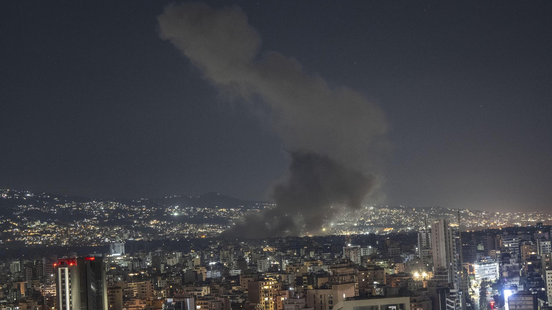 Nachtpanorama des Beiruter Viertels Dahieh: In der Skyline steigt eine Rauchsäule auf.