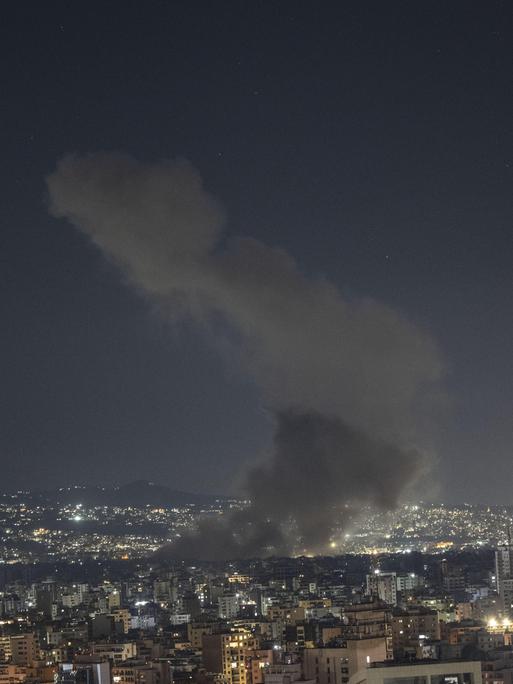 Nachtpanorama des Beiruter Viertels Dahieh: In der Skyline steigt eine Rauchsäule auf.