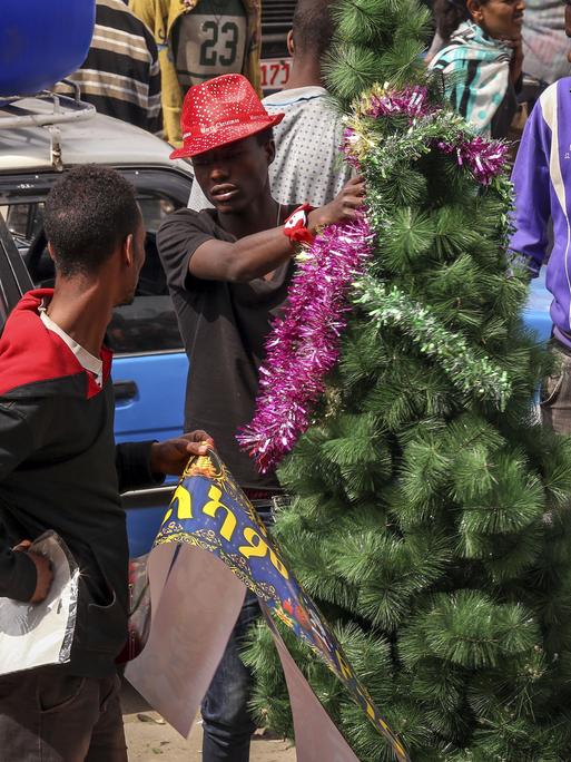 Menschen kaufen in Äthiopiens Hauptstadt Addis Abeba Weihnachtsbäume ein.