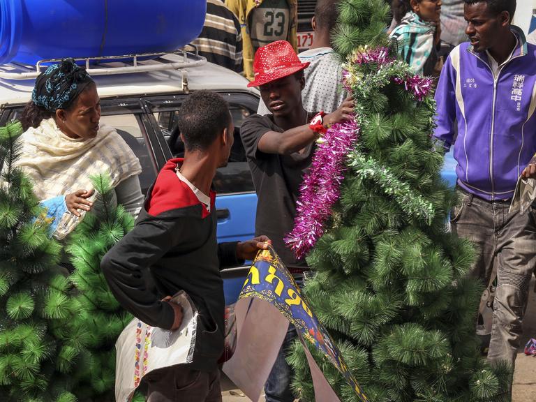 Menschen kaufen in Äthiopiens Hauptstadt Addis Abeba Weihnachtsbäume ein.