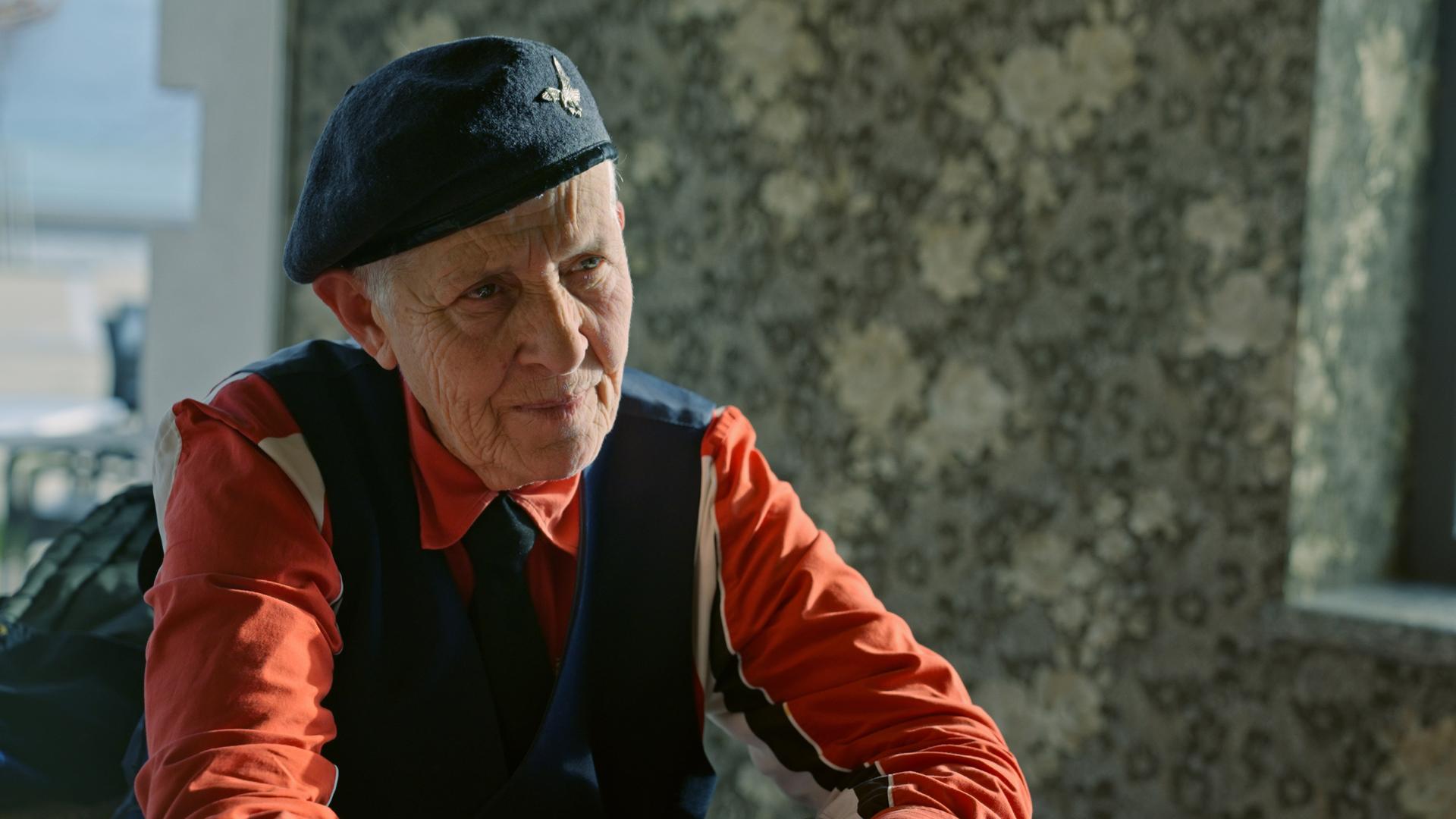 Ein Filmstill aus dem Dokumentarfilm " WO/MEN" zeigt eine Frau mit einer Mütze, einem Barett, auf dem Kopf Ein Filmstill aus dem Dokumentarfilm " WO/MEN" zeigt eine Frau mit einer Mütze, einem Barett, auf dem Kopf