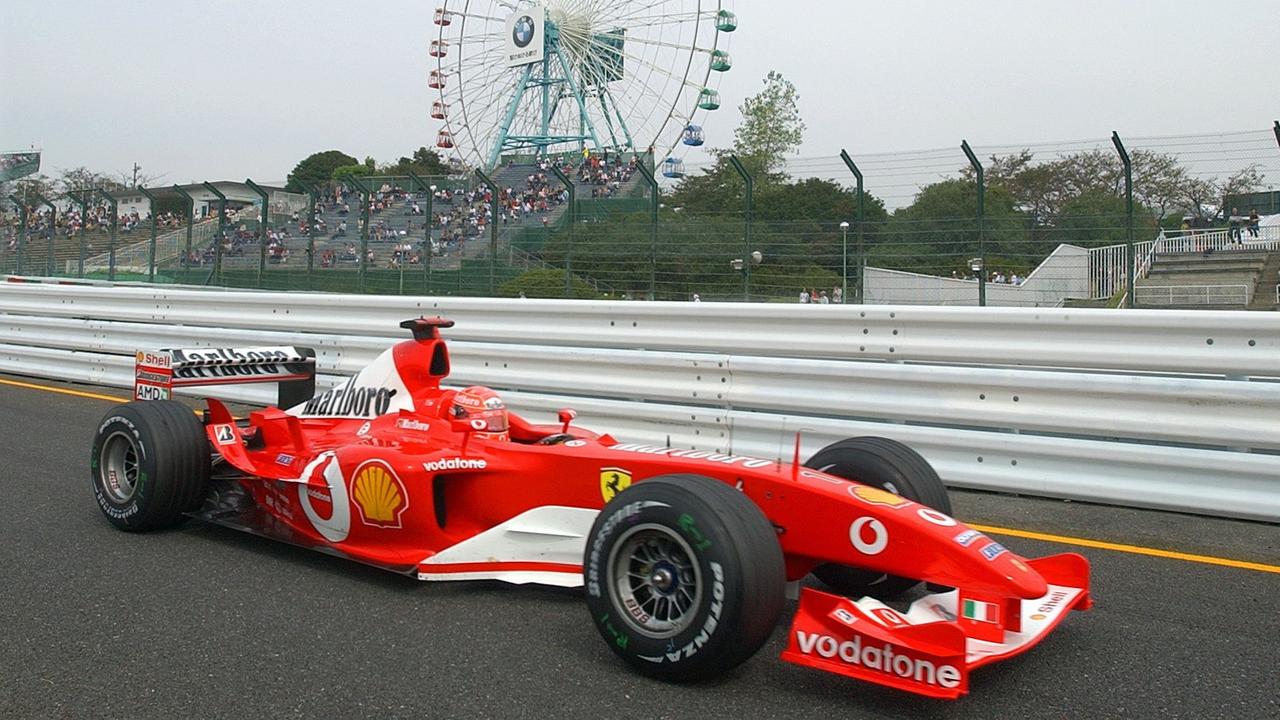 Michael Schumacher (Ferrari) fährt 2003 beim freien Training auf der Strecke vor einem Riesenrad in Suzuka in Japan. Michael Schumacher (Ferrari) fährt 2003 beim freien Training auf der Strecke vor einem Riesenrad in Suzuka in Japan.