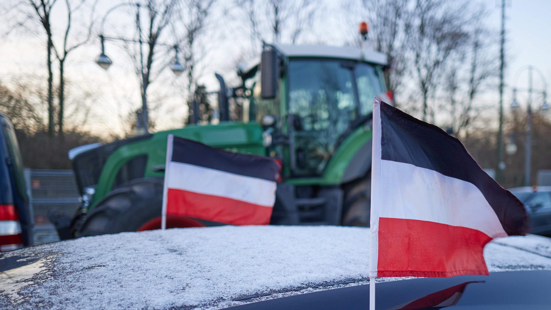Reichsflaggen sind am Rande eines Bauernprotests auf der Straße des 17. Juni vor dem Brandenburger Tor an einem PKW zu sehen. 