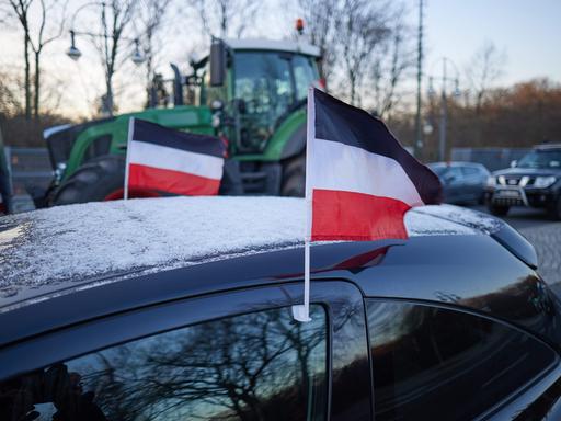 Reichsflaggen sind am Rande eines Bauernprotests auf der Straße des 17. Juni vor dem Brandenburger Tor an einem PKW zu sehen. 