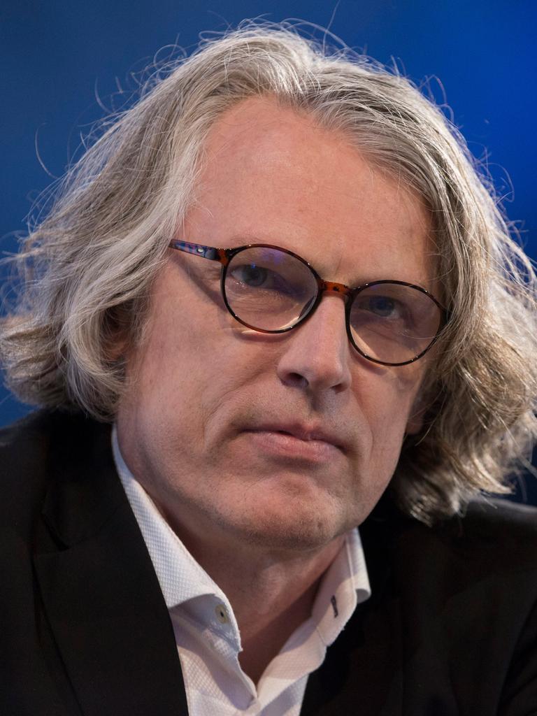 Peter Trawny auf der Buchmesse. Er hat mittellanges graues Haar, trägt eine Brille und ein weißes Hemd zum dunklen Anzug.