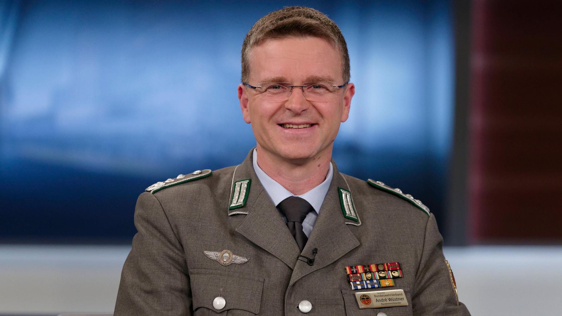 Andre Wüstner, Vorsitzender des Bundeswehrverbandes und Oberst, lächelt in die Kamera. Er trägt eine Uniform.