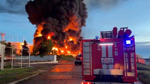 Rauch und Flammen steigen aus einem brennenden Treibstofftank in Sewastopol auf der Krim auf. Im Vordergrund ist ein Feuerwehrauto zu sehen.