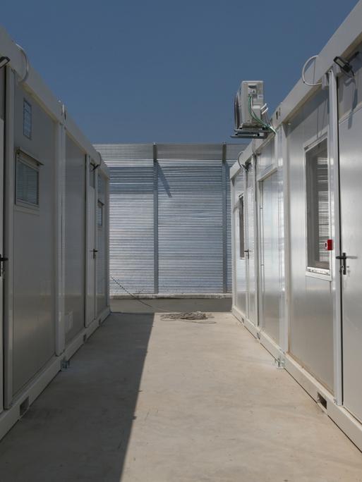 Bei Bauarbeiten in einem Lager in Gjader sind erste neu errichtete und enge Wohncontainer zu sehen. Das Camp liegt einige Kilometer von der Hafenstadt Shengjin entfernt im nördlichen Albanien.