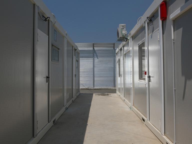 Bei Bauarbeiten in einem Lager in Gjader sind erste neu errichtete und enge Wohncontainer zu sehen. Das Camp liegt einige Kilometer von der Hafenstadt Shengjin entfernt im nördlichen Albanien.