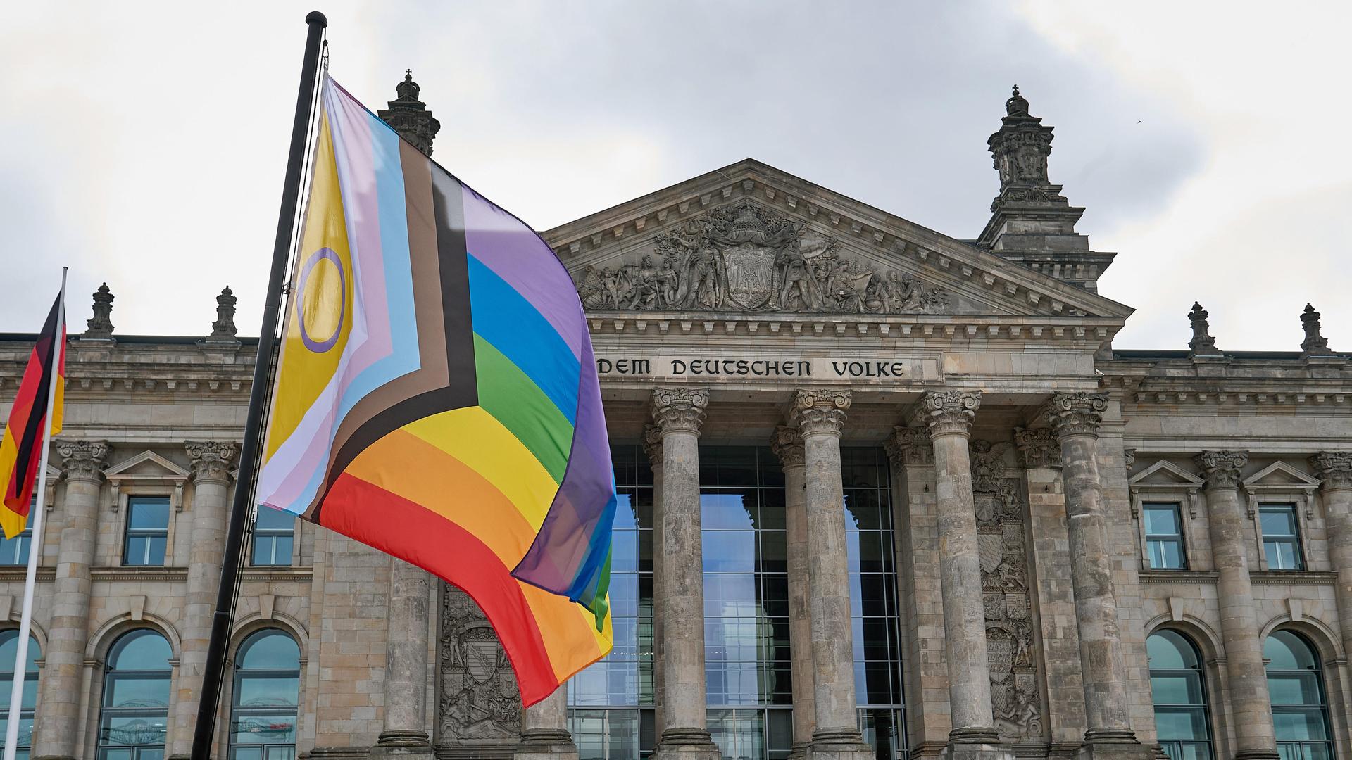 Eine Regenbogenflagge vor dem Reichstagsgebäude in Berlin, aufgenommen während einer öffentlichen Aktion
