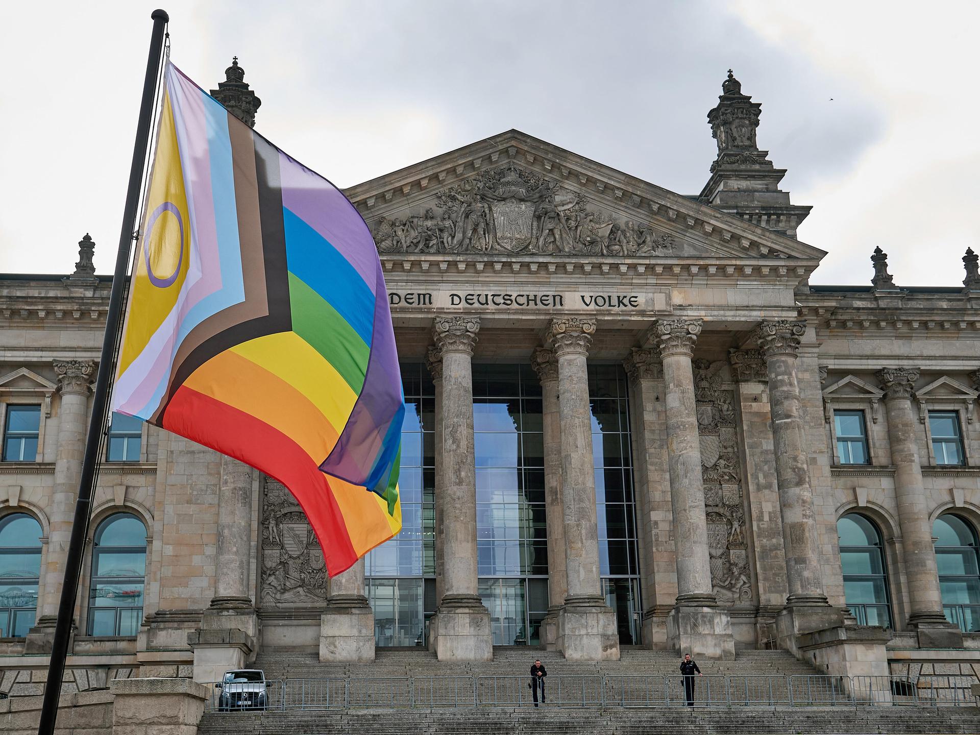 Eine Regenbogenflagge vor dem Reichstagsgebäude in Berlin, aufgenommen während einer öffentlichen Aktion
