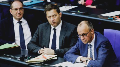 Alexander Dobrindt, Lars Klingbeil und Friedrich Merz sitzen nebeneinander im Bundestag.