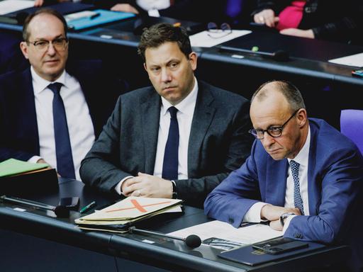 Alexander Dobrindt, Lars Klingbeil und Friedrich Merz sitzen nebeneinander im Bundestag.