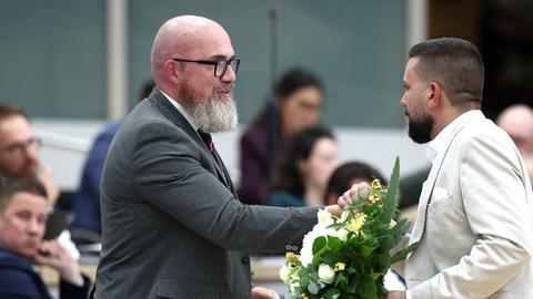Tobias Rausch (r, AfD) gratuliert Hans-Thomas Tillschneider (AfD) zu dessen Wahl zum stellvertretenden Landtagspräsidenten während der konstituierenden Sitzung des Landtags in Sachsen-Anhalt. Rausch hält Blumen in der Hand.