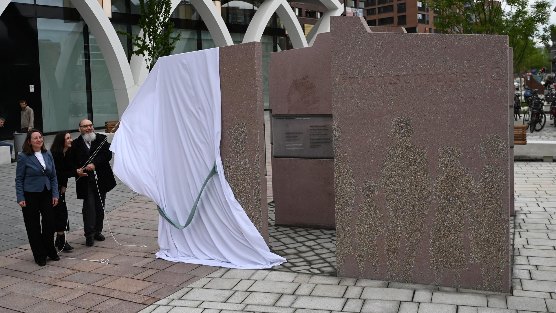 Bei der Zeremonie zur Einweihung wird das aus mehreren Steinplatten bestehende Denkmal "Fruchtschuppen C" enthüllt. Bei der Zeremonie zur Einweihung wird das aus mehreren Steinplatten bestehende Denkmal "Fruchtschuppen C" enthüllt.