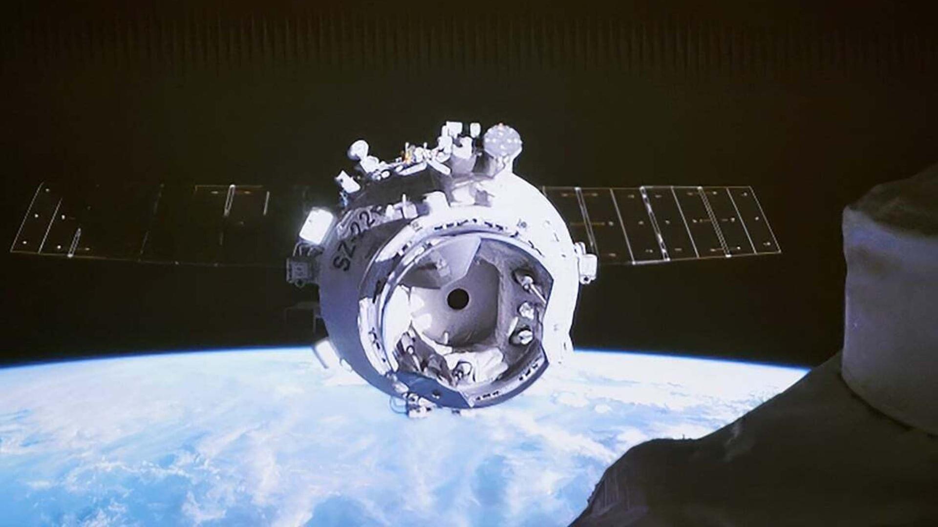 Foto der unbemannten Kapsel Shenzhou-22, im Hintergrund ist die Erde zu sehen