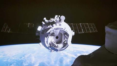 Foto der unbemannten Kapsel Shenzhou-22, im Hintergrund ist die Erde zu sehen