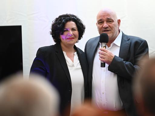 Robert Crumbach (r), Spitzenkandidat des Bündnis Sahra Wagenknecht (BSW) in Brandenburg, und Amira Mohamed Ali, Co-Vorsitzende des Bündis Sahra Wagenknecht sprechen gemeinsam auf der Bühne bei der Wahlparty anlässlich der Landtagswahlen in Brandenburg.