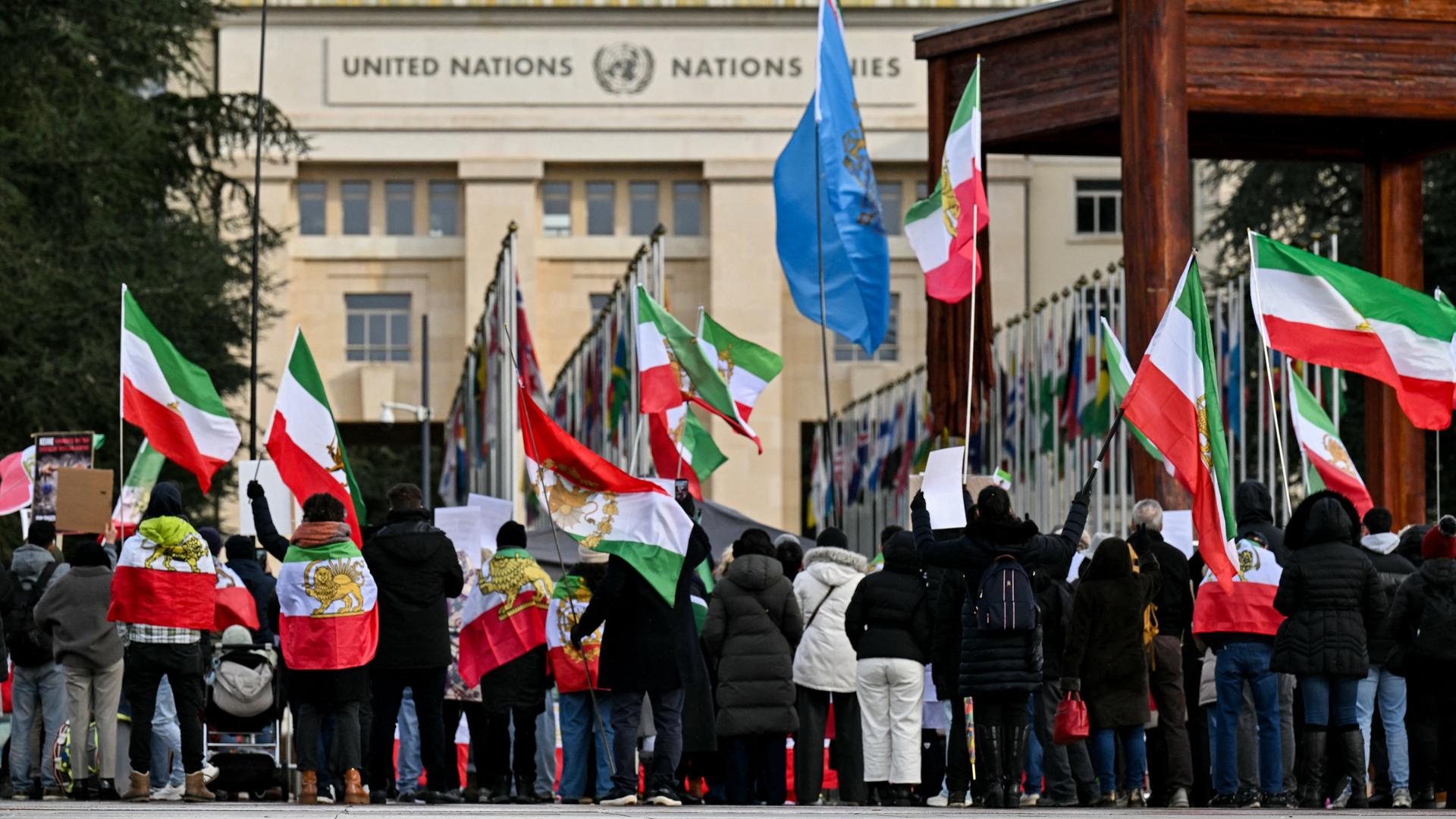 Demonstranten halten vor den USA-Iran-Gesprächen in Genf Flaggen in die Höhe.