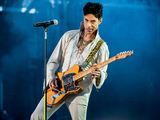 Prince Rogers Nelson mit E-Gitarre auf der Bühne (2011 in England)