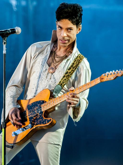 Prince Rogers Nelson mit E-Gitarre auf der Bühne (2011 in England)