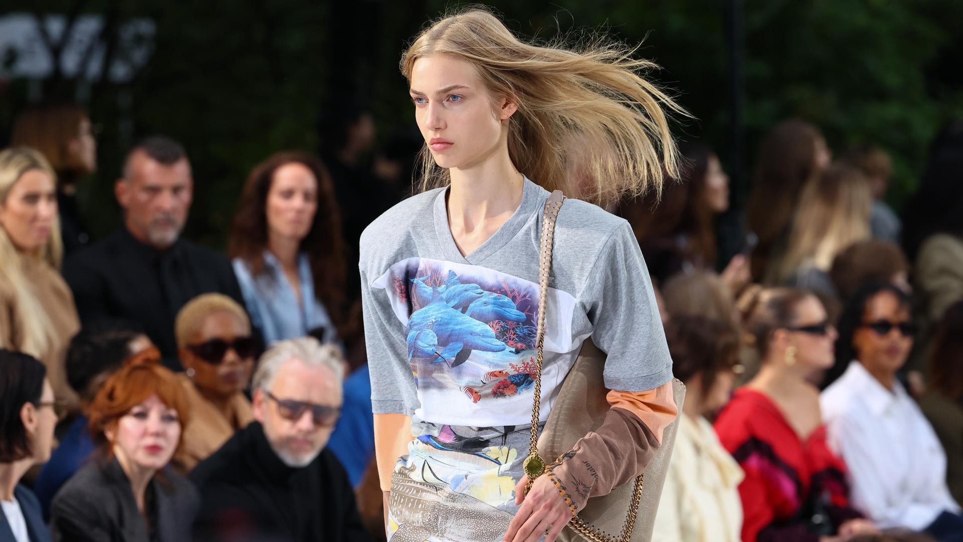 Ein Model auf dem Laufsteg während der Stella McCartney Damenmodenschau Frühjahr/Sommer 2027 im Rahmen der Pariser Modewoche trägt ein Top mit einem Motiv, das Delphine und Wale zeigt. Ein Model auf dem Laufsteg während der Stella McCartney Damenmodenschau Frühjahr/Sommer 2027 im Rahmen der Pariser Modewoche trägt ein Top mit einem Motiv, das Delphine und Wale zeigt.