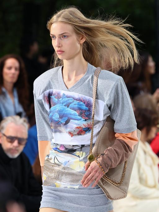 Ein Model auf dem Laufsteg während der Stella McCartney Damenmodenschau Frühjahr/Sommer 2027 im Rahmen der Pariser Modewoche trägt ein Top mit einem Motiv, das Delphine und Wale zeigt. Ein Model auf dem Laufsteg während der Stella McCartney Damenmodenschau Frühjahr/Sommer 2027 im Rahmen der Pariser Modewoche trägt ein Top mit einem Motiv, das Delphine und Wale zeigt.