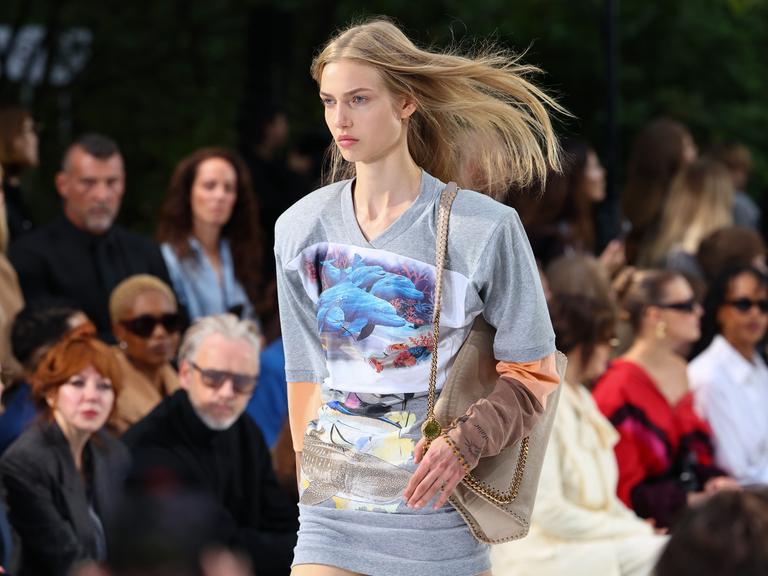 Ein Model auf dem Laufsteg während der Stella McCartney Damenmodenschau Frühjahr/Sommer 2027 im Rahmen der Pariser Modewoche trägt ein Top mit einem Motiv, das Delphine und Wale zeigt. Ein Model auf dem Laufsteg während der Stella McCartney Damenmodenschau Frühjahr/Sommer 2027 im Rahmen der Pariser Modewoche trägt ein Top mit einem Motiv, das Delphine und Wale zeigt.