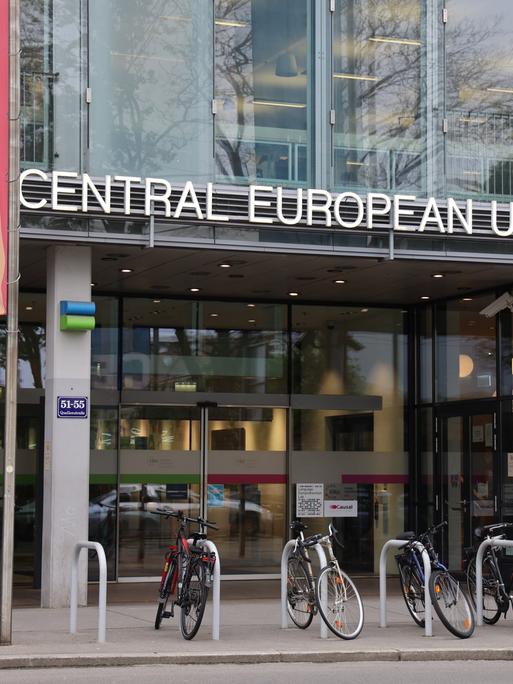 Die Glasfassade des Eingangs der Central European University in Wien, davor stehen Fahrräder.